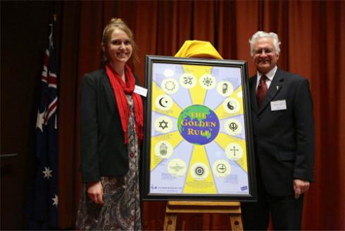 Columban Mission Institute staff, Ashleigh Green and Fr Brian Vale, with The Golden Rule poster.