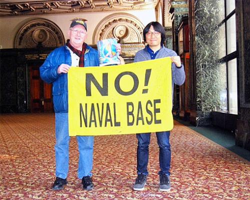 Columban Fr Pat Cunningham and Joyakgol, a peace activist from Gangjeong Village, holding a banner at the 2014 Peace on Earth Film Festival (POEFF) in Chicago.