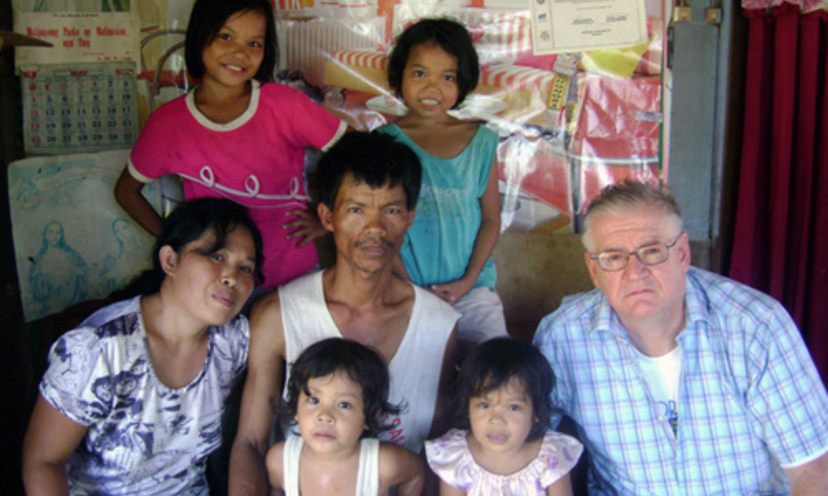 Jerry, Wilda, and their children seated with Fr. Oliver McCrossan - Photo: Columban Mission
