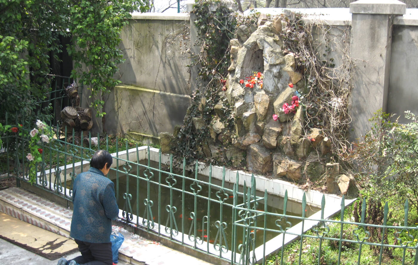 A person in China praying in front of a grotto. Photo: Fr George Hogarty SSC