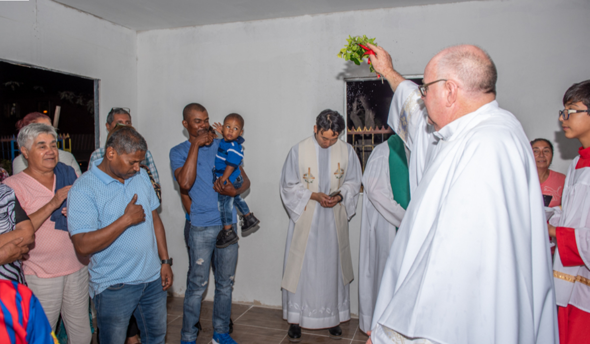 Columban Fr Daniel Harding blesses migrants during the inauguration and blessing of the San Columbano Shelter and the Migrant Hall. Photo: Columbans Chile